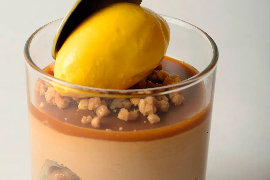 Banoffee. Plátano caramelizado, mousse de chocolate con leche y sorbete de mango