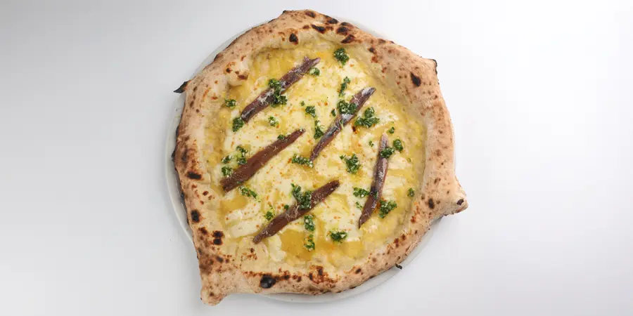 Imagen de Pizza Perfume de Mar con base de tomate amarillo, mozzarella, anchoas y ralladura de limón de Cal Jan