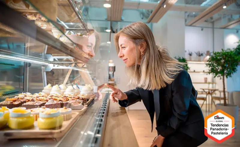 Mujer mirando vitrina de pastelería