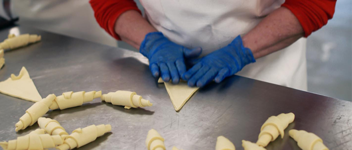 Trabajadora de Pastelería Mallorca enrolladno croissants